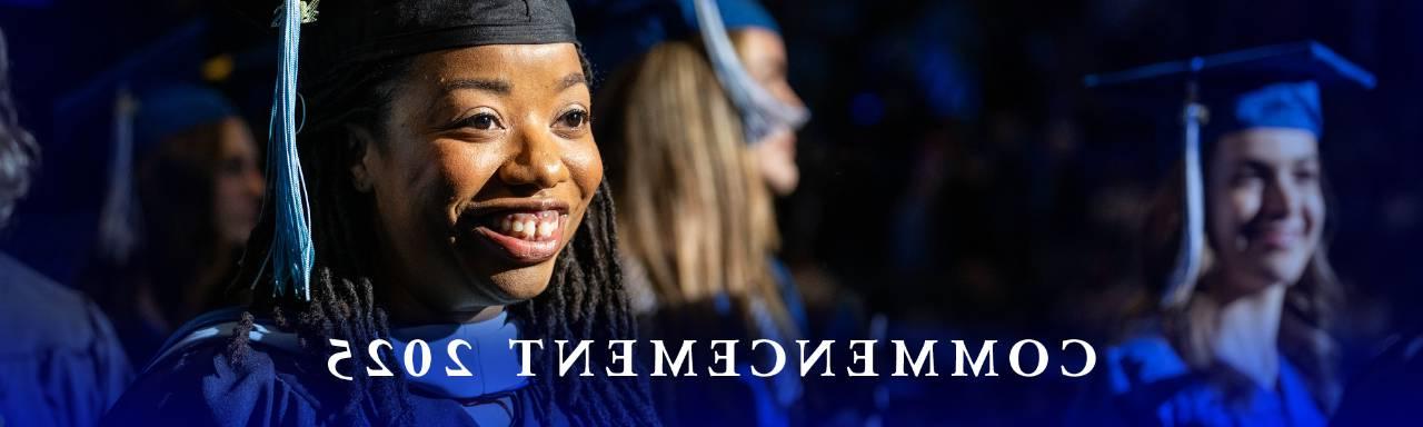 graduate smiling in blue cap and gown - Commencement 2025